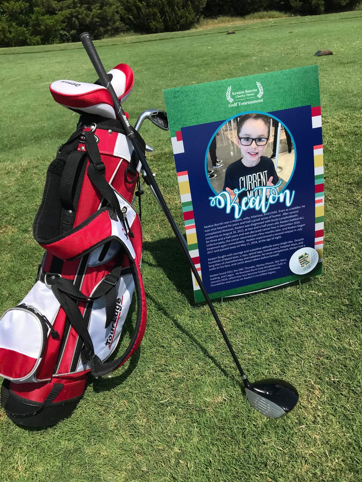 A golf bag next to a sign with Keaton's photo