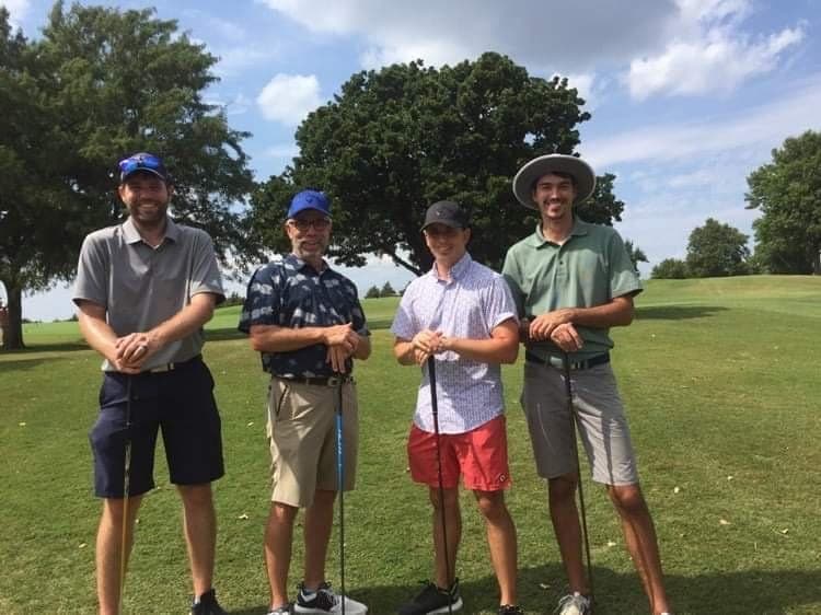 A foursome posing on the course