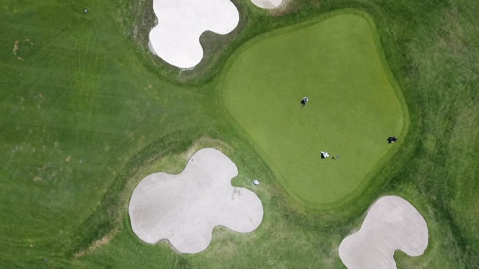 An aerial view of a golf green and bunkers