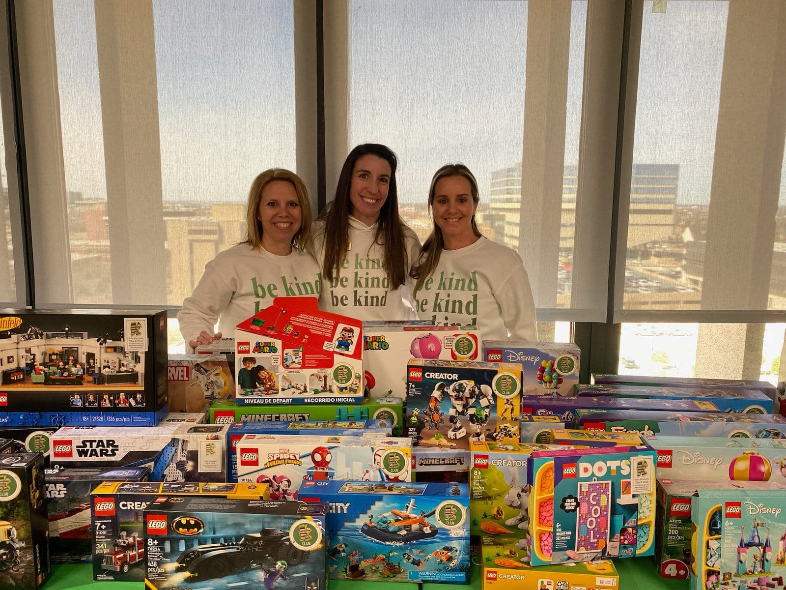 K Club volunteers with a table full of donated Lego sets