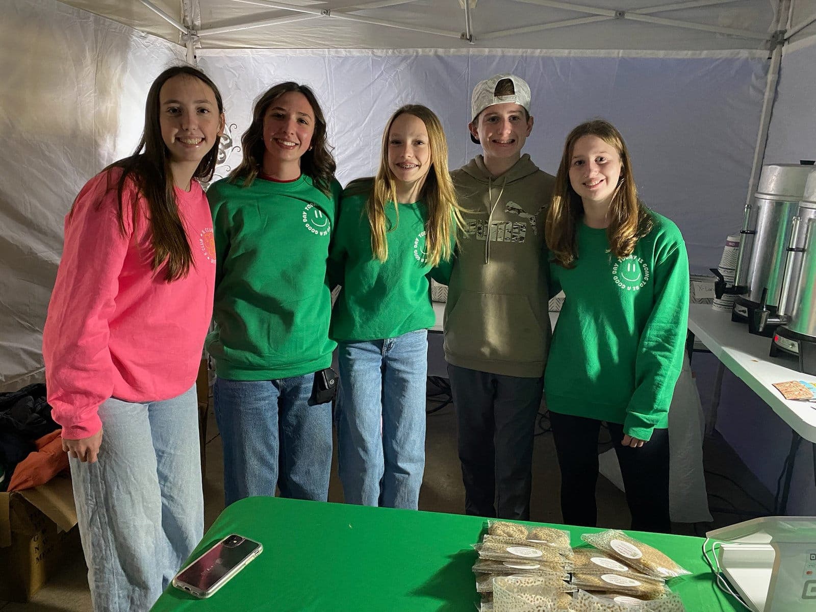 K Club volunteers at a booth with green tablecloths